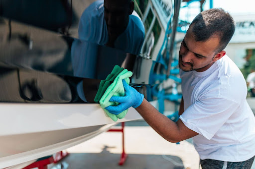  man cleaning a boat with a cloth