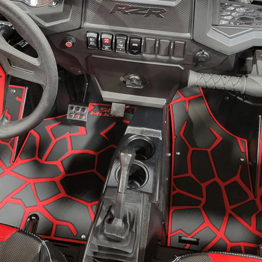 close-up shot of red and black patterned SeaDek UTV floor mats installed inside an all-terrain vehicle