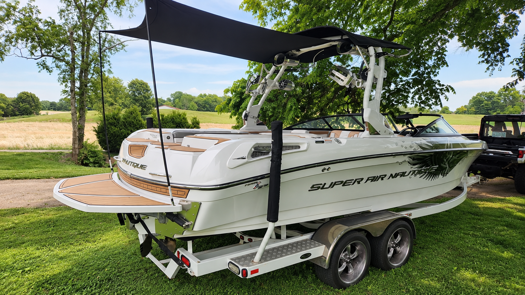 A boat, trailered on land, fitted with a SeaDek canopy